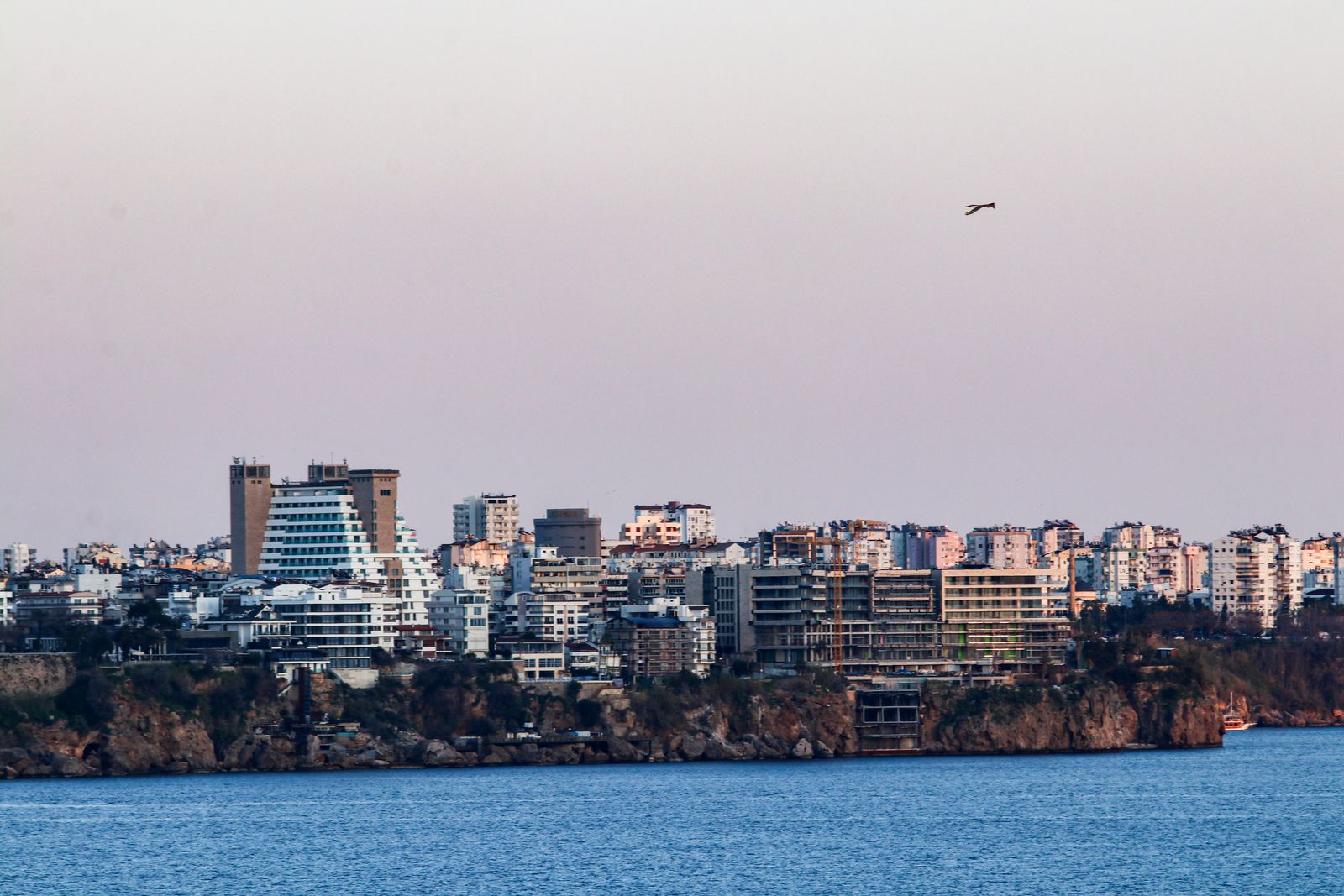 Photo: Ahmet / Pexels Mediterranean coastal skyline at dusk with apartment blocks along the shore